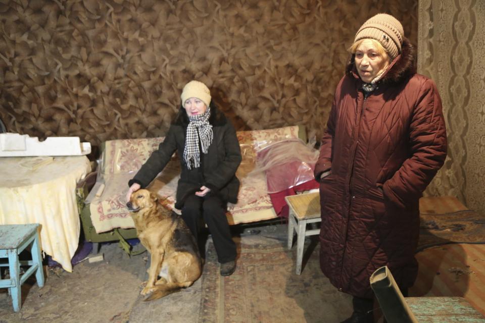 FILE - Tatyana, left, and Liliya, both residents of Donetsk-Severne village in the outskirts of Donetsk, speak to a journalist in a basement used as a bomb shelter on the territory controlled by pro-Russian militants not far from the frontline with Ukrainian government forces, eastern Ukraine, Jan. 30, 2022. Amid fears of a Russian invasion of Ukraine, tensions have also soared in the country’s east, where Ukrainian forces are locked in a nearly eight-year conflict with Russia-backed separatists. A sharp increase in skirmishes on Thursday raised fears that Moscow could use the situation as a pretext for an incursion. (AP Photo/Alexei Alexandrov, File)