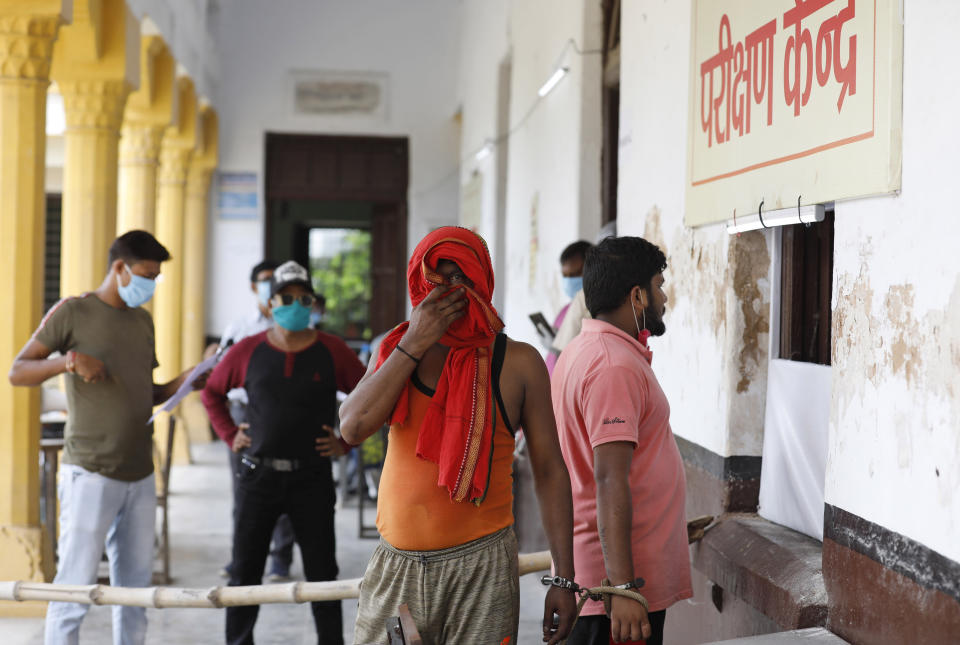 Prisoners, handcuffed to another, wait to give their nasal swab samples to test for COVID-19 in Prayagraj, India, Friday, Aug. 7, 2020. As India hit another grim milestone in the coronavirus pandemic on Friday, crossing 2 million cases and more than 41,000 deaths, community health volunteers went on strike complaining they were ill-equipped to respond to the wave of infection in rural areas. (AP Photo/Rajesh Kumar Singh)