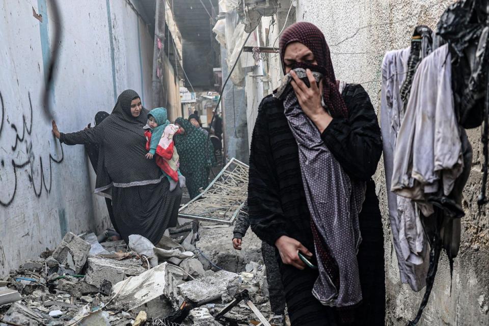 People find their way through a rubble-covered alley, following overnight Israeli bombardment in Rafah on Sunday (AFP via Getty Images)