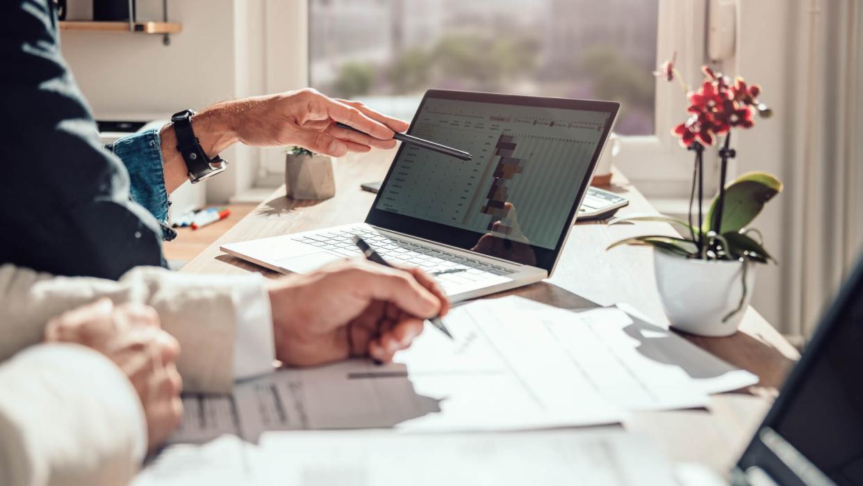 Businessman sitting by the desk and analyzing project timeline.