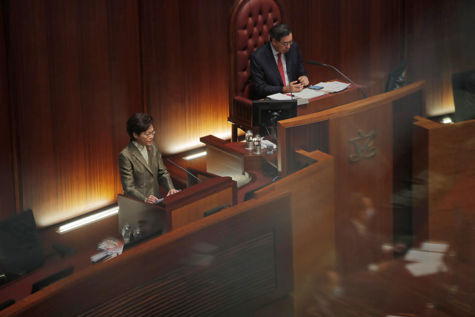 Hong Kong Chief Executive Carrie Lam, left, delivers her policies at chamber of the Legislative Council in Hong Kong, Wednesday, Nov. 25, 2020. Lam said Wednesday that the city's new national security law has been “remarkably effective in restoring stability” after months of political unrest, and that bringing normalcy back to the political system is an urgent priority. (AP Photo/Kin Cheung)