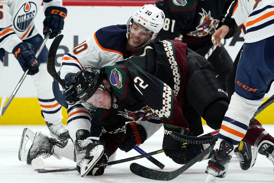 Edmonton Oilers center Derek Ryan (10) and Arizona Coyotes center Travis Boyd (72) tangle after a faceoff during the first period of an NHL hockey game Thursday, Oct. 21, 2021, in Glendale, Ariz. (AP Photo/Ross D. Franklin)