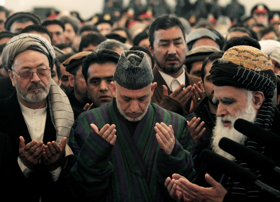 Afghan President Hamid Karzai, center, prays during the funeral procession of Afghanistan's influential Vice President Mohammad Qasim Fahim in Kabul, Afghanistan, Tuesday, March 11, 2014. Fahim, a leading commander in the alliance that fought the Taliban who was later accused with other warlords of targeting civilian areas during the country's civil war, died on Sunday, March 9, 2014. He was 57. (AP Photo/Rahmat Gul)