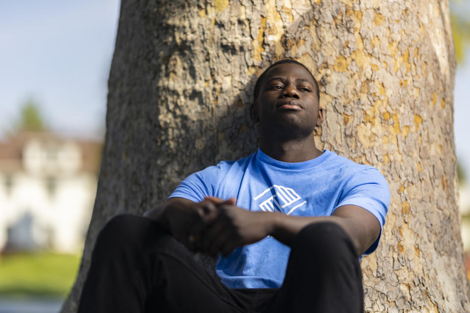 Steeve Biondolillo sits for a portrait on campus at Northwest Nazarene University in Nampa, Idaho on Friday, Oct. 7, 2022. Adopted as a child in Haiti, Biondolillo's new life in the United States gave him opportunities he never dreamed of, but he says he was still haunted by “the baggage and trauma that I had from Haiti.’’ (AP Photo/Kyle Green)