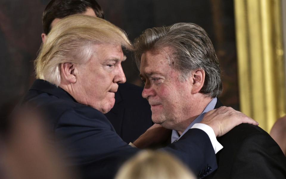  President Donald Trump (L) congratulates Senior Counselor to the President Stephen Bannon during the swearing-in of senior staff in the East Room of the White House in Washington, DC. - MANDEL NGAN/ AFP