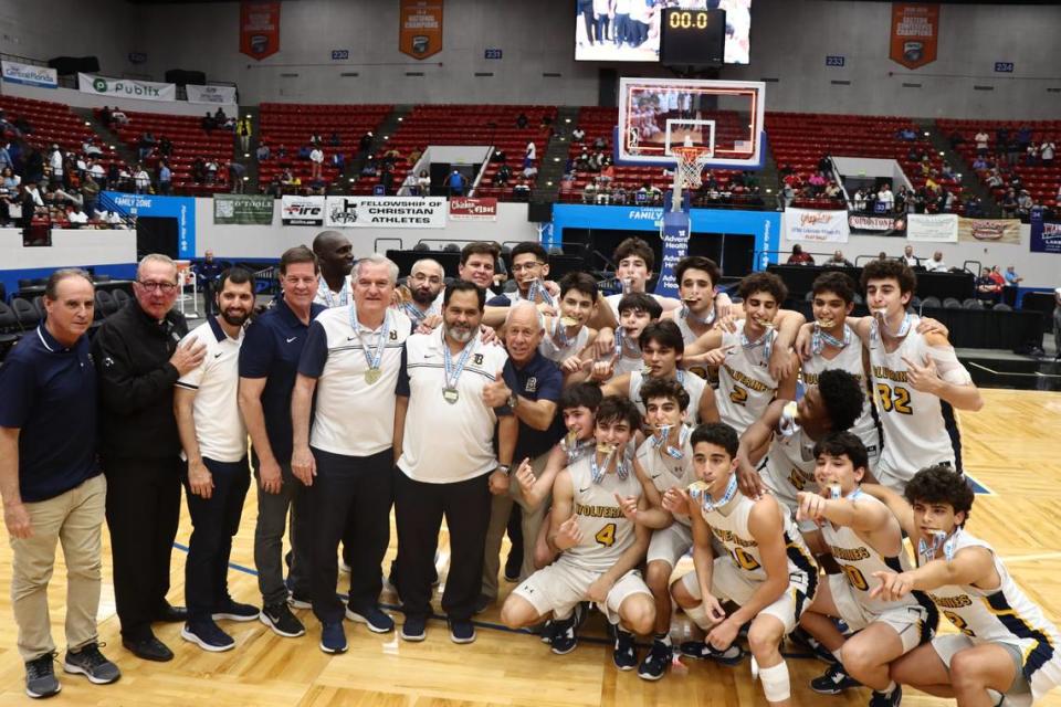Belen Jesuit’s Carlos Barquin (middle) celebrates with the Wolverines’ boys’ basketball team this past March after they won the school’s first state championship in the sport in Lakeland, Fla.