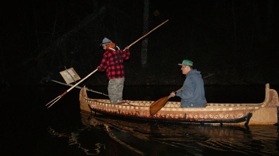 Wayne Valliere and his apprentice Lawrence Mann use a handmade birchbark canoe and other traditional gear to spearfish.
