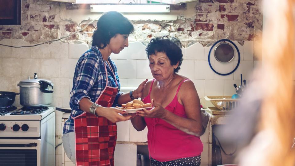 Multi-generation cuban family preparing dinner.