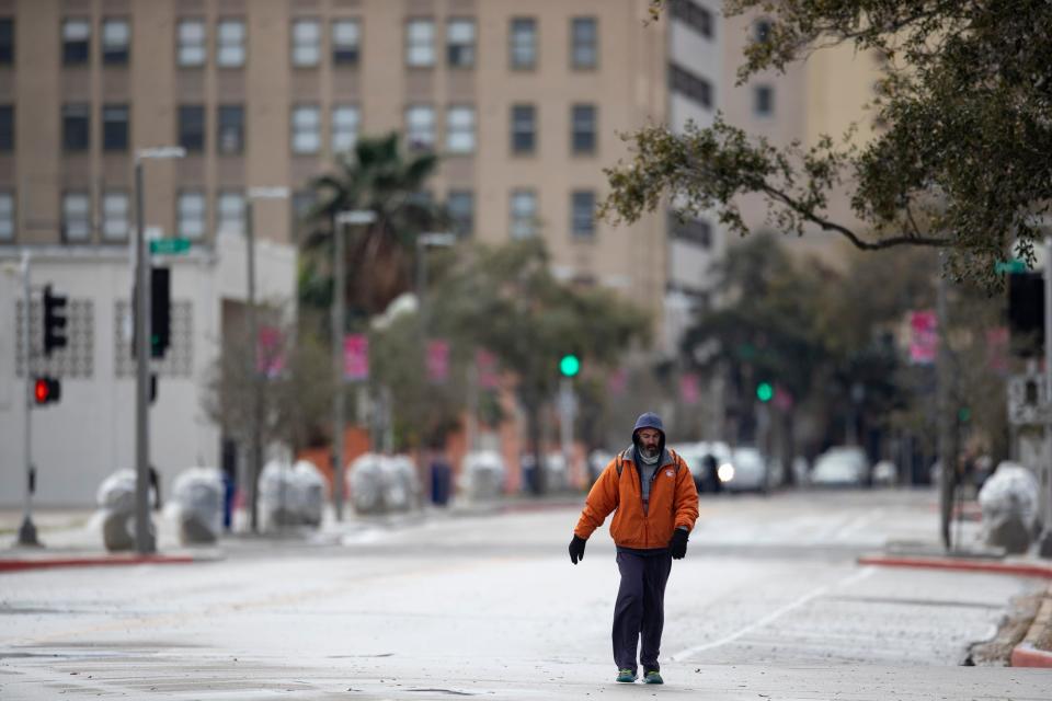 A man walks down Water Street in freezing temperatures on Monday, Feb. 15, 2021. An arctic cold front is bringing freezing temperatures to South Texas later this week.