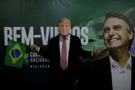 FILE PHOTO: A supporter of Federal deputy Jair Bolsonaro wears a mask of U.S. President Donald Trump before the national convention of the Social Liberal Party (PSL) where he is to be formalised as a candidate for the Presidency of the Republic, in Rio de Janeiro, Brazil July 22, 2018. REUTERS/Ricardo Moraes/File photo