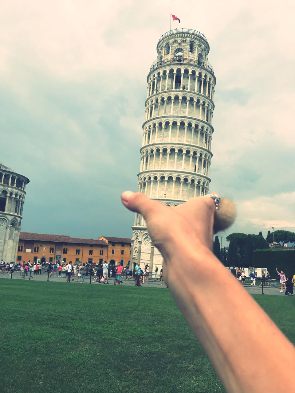 A hand pretending to hold the Leaning Tower of Pisa