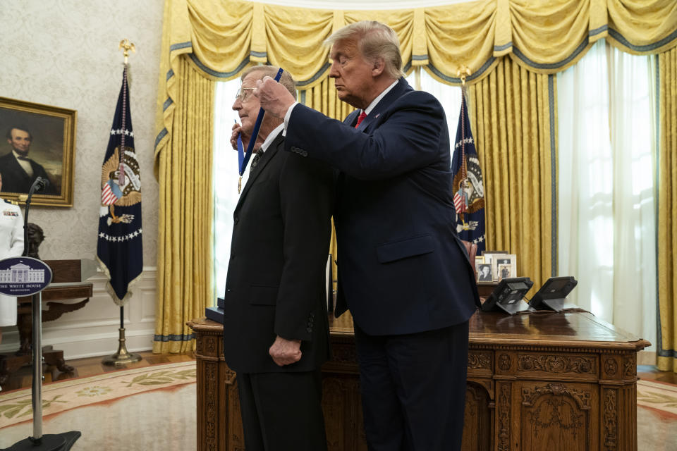 President Donald Trump presents the Presidential Medal of Freedom to former football coach Lou Holtz, in the Oval Office of the White House, Thursday, Dec. 3, 2020, in Washington. (AP Photo/Evan Vucci)