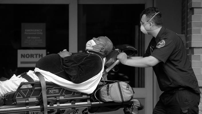 A paramedic takes a patient into an emergency center