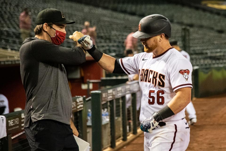 Redding native Drew Hedman daps former outfielder Kole Calhoun during a game against the Houston Astros in 2021.