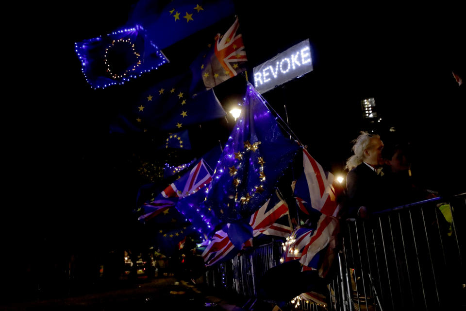 European flags are held by remain in the EU supporters as they demonstrate opposite the Houses of Parliament in London, Wednesday, Sept. 4, 2019. With Britain's prime minister weakened by a major defeat in Parliament, defiant lawmakers were moving Wednesday to bar Boris Johnson from pursuing a "no-deal" departure from the European Union. (AP Photo/Matt Dunham)