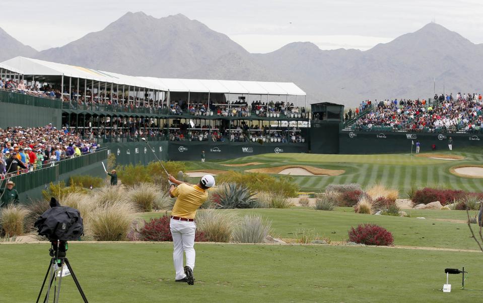 Surrounded by spectators, Ki Taek Lee hits his tee shot on the 16th hole during the second round of the Phoenix Open golf tournament on Friday, Jan. 31, 2014, in Scottsdale, Ariz. (AP Photo/Ross D. Franklin)