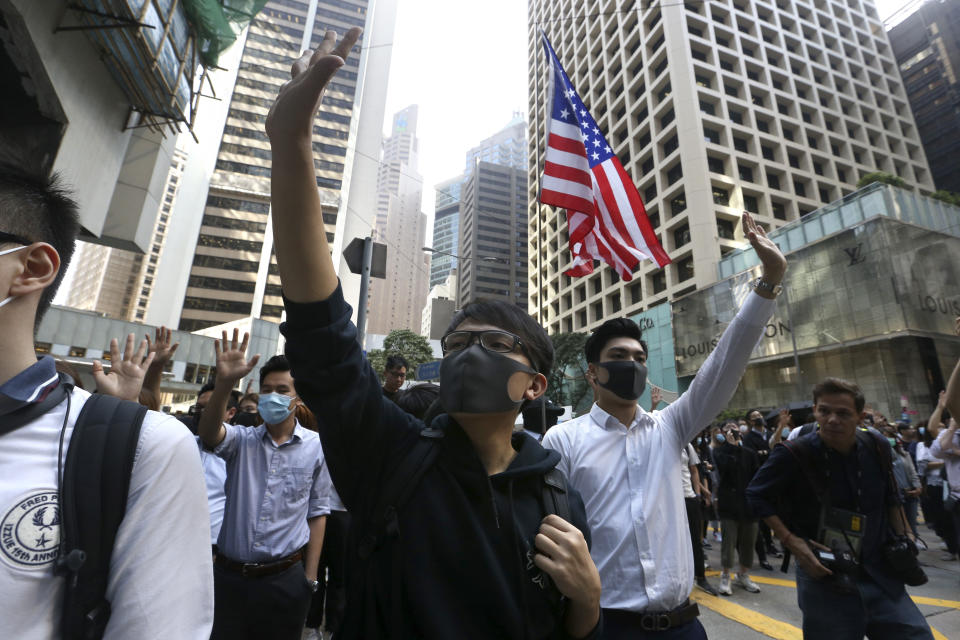 Demonstrators raise their hands during a protest in the financial district in Hong Kong, Friday, Nov. 15, 2019. Protesters who have barricaded themselves in a Hong Kong university partially cleared a road they were blocking and demanded that the government commit to holding local elections on Nov. 24. (AP Photo/Achmad Ibrahim)