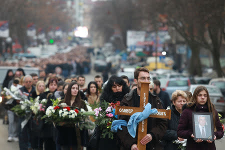 A cortege escorts a car carrying coffin of Oliver Ivanovic, flanked by priests and family, to the northern outskirts of Kosovska Mitrovica, Kosovo, January 17, 2018. REUTERS/Djordje Kojadinovic