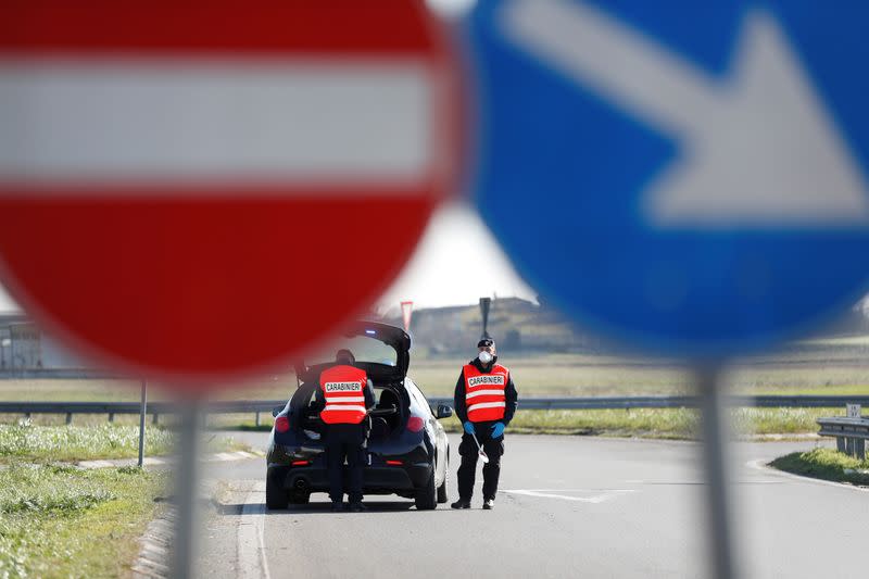 Members of the Italian Carabinieri guard the entrance of the red zone of Casalpusterlengo