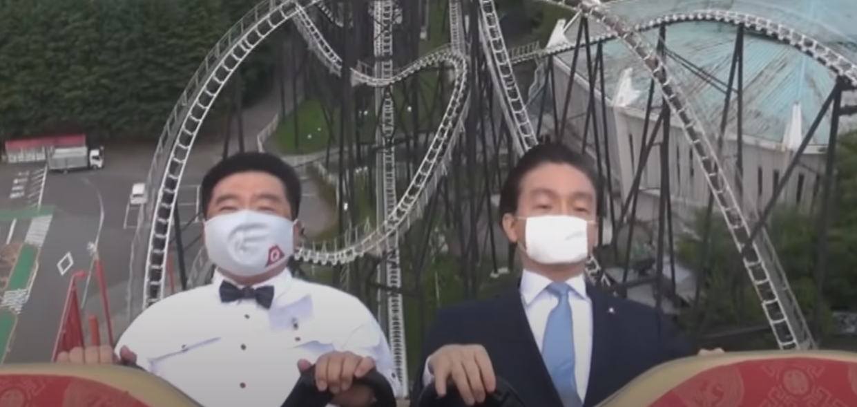 Executives demonstrating the 'no screaming' policy on a rollercoaster in a Japanese theme park (Fuji-Q Highland). 