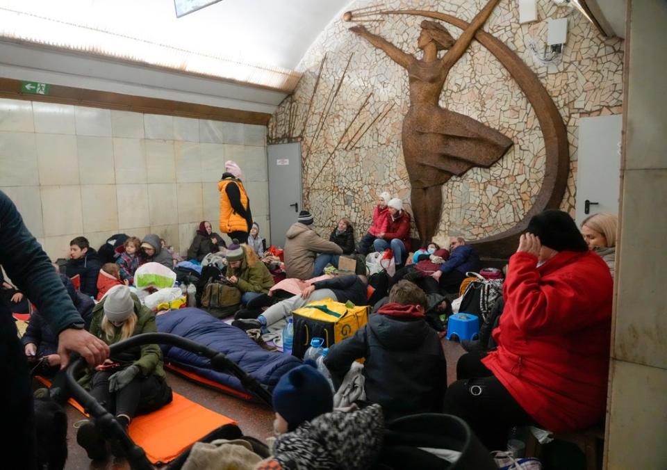 People hiding out in a subway station in Kyiv (AP)