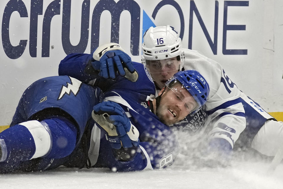 Tampa Bay Lightning defenseman Erik Cernak (81) and Toronto Maple Leafs right wing Mitchell Marner (16) fall to the ice after crashing into each other during the first period of an NHL hockey game Saturday, Oct. 21, 2023, in Tampa, Fla. (AP Photo/Chris O'Meara)