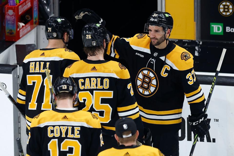 Boston Bruins' Patrice Bergeron (37) greets teammates as they file off the ice after losing to the Florida Panthers in overtime during Game 7 of an NHL hockey Stanley Cup first-round playoff series, Sunday, April 30, 2023, in Boston. (AP Photo/Michael Dwyer)