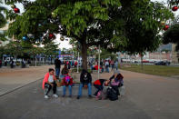 People in a caravan of migrants departing from El Salvador en route to the United States wait at El Salvador del Mundo Square, in San Salvador, El Salvador, November 18, 2018. REUTERS/Jose Cabezas