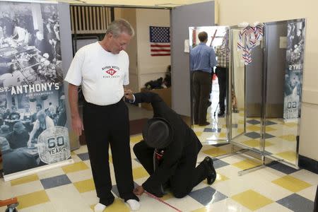 Military veteran Tom Clemes (L) tries on a suit as fellow veteran Del Seymout takes measurements, in San Francisco, California November 10, 2014. REUTERS/Robert Galbraith