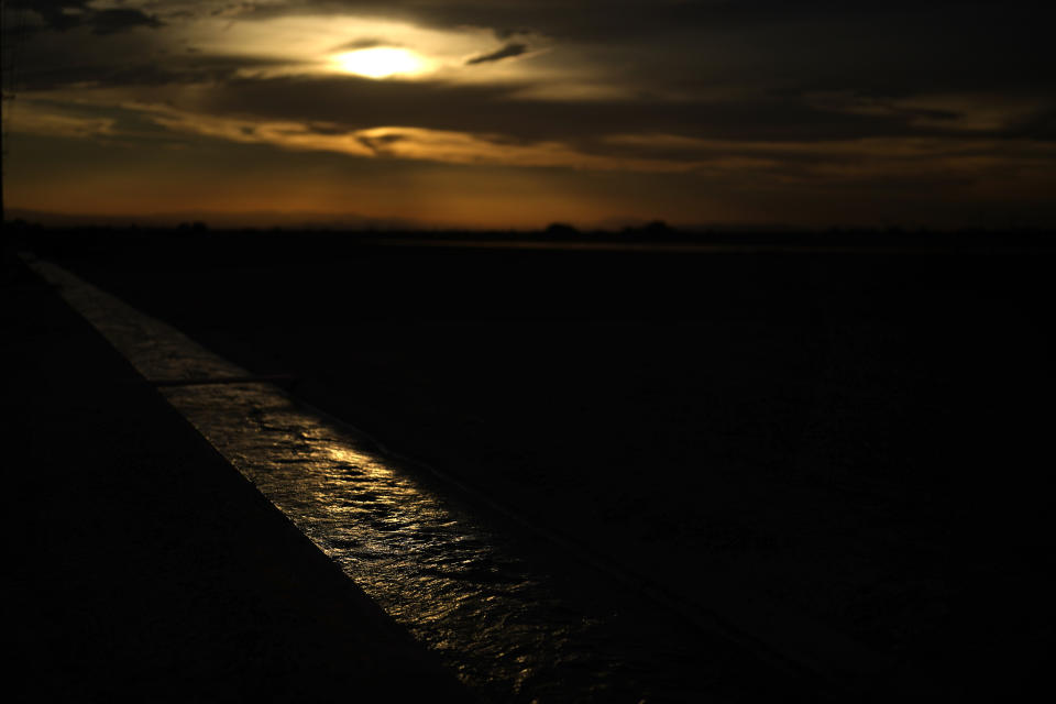 Water from the All-American Canal flows in a canal alongside fields Saturday, Aug. 13, 2022, near El Centro, Calif. The canal conveys water from the Colorado River into the Imperial Valley. (AP Photo/Gregory Bull)