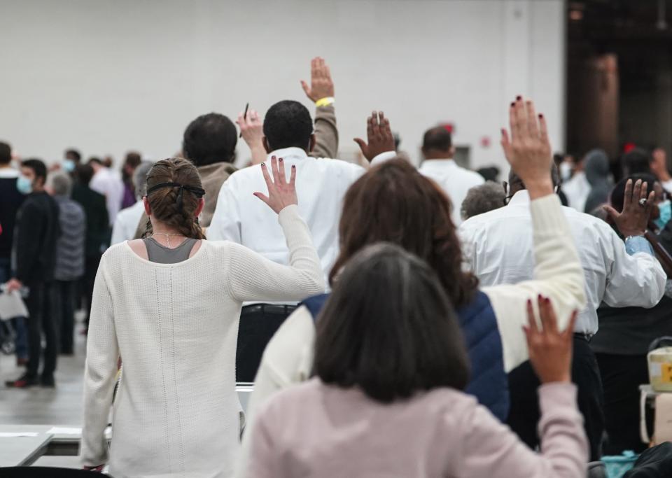 Poll workers take an oath before counting absentee ballots for the city of Detroit at the TCF Center in downtown Detroit on Tuesday, Nov. 3, 2020. 