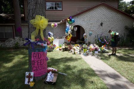 Ribbons, candles, cards, flowers and stuffed animals are among the items wellwishers are leaving at the house where six members of the Stay family were murdered on Wednesday in Spring, Texas July 12, 2014. REUTERS/Daniel Kramer