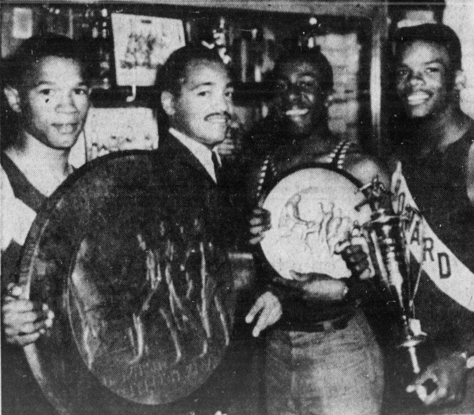 Spencer Henry, coach Quinton Sterling, Courtland Camper and Lee Williams pose with Penn Relays Championship of America wheel after Howard's 440-yard relay win at the 1962 Penn Relays.