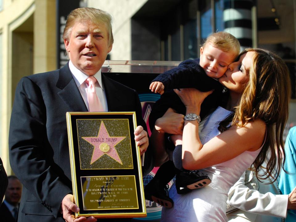 Donald Trump holds a replica of his star on the Hollywood Walk of Fame as his wife Melania holds their son Barron in Los Angeles, January 16, 2007