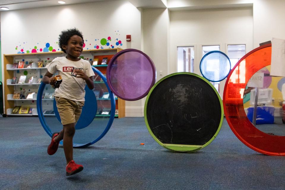 Lamari Nelson, a 6-year-old from West Palm Beach, runs across the children’s section of the Mandel Public Library in West Palm Beach on Thursday. The Mandel Public Library was recently named one of the most beautiful libraries in the United States by Fodor’s Travel.