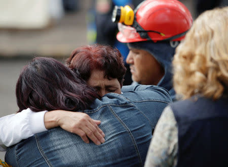 Family members of people still buried under the rubble of a collapsed building hug near the site, after an earthquake in Mexico City, Mexico September 26, 2017. REUTERS/Jose Luis Gonzalez