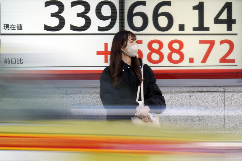 A person stands in front of an electronic stock board showing Japan's Nikkei 225 index at a securities firm Tuesday, Jan. 9, 2024, in Tokyo. (AP Photo/Eugene Hoshiko)