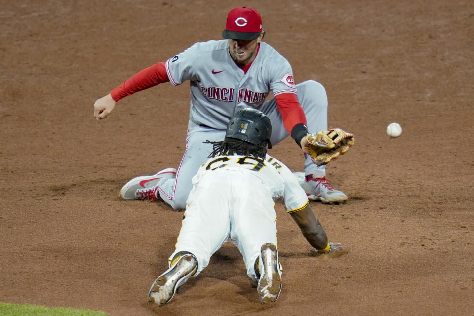 The throw from Cincinnati Reds catcher Tucker Barnhart gets past shortstop Kyle Farmer as Pittsburgh Pirates' Troy Stokes Jr. steals second during the sixth inning of a baseball game, Tuesday, May 11, 2021, in Pittsburgh. (AP Photo/Keith Srakocic)