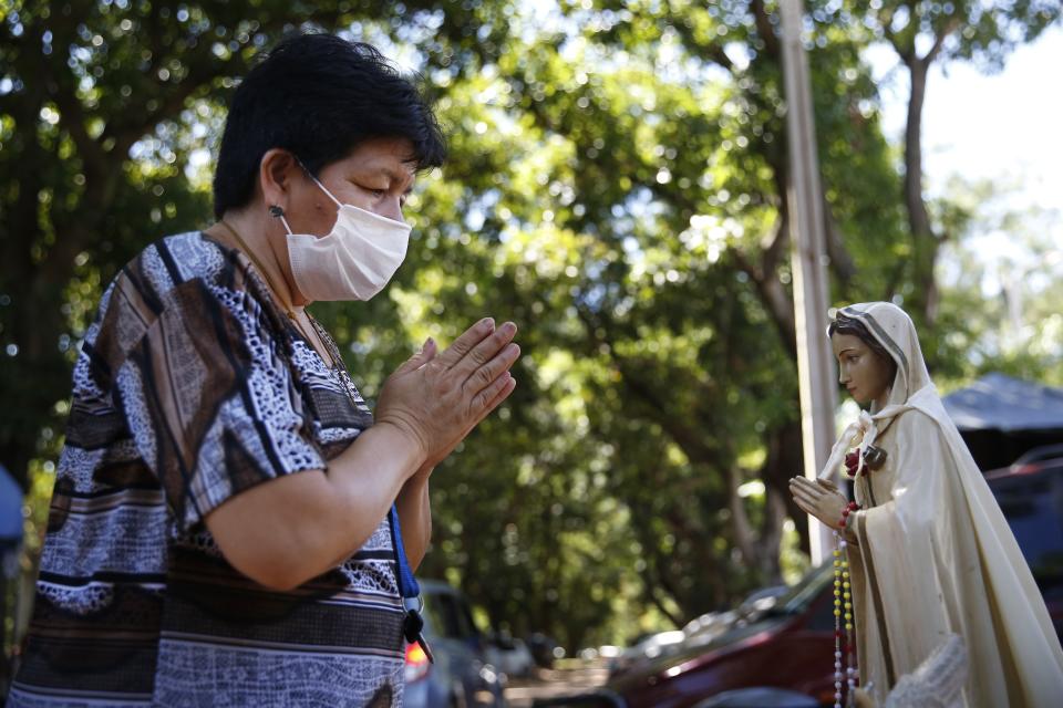 A woman prays before a statue of the Virgin Mary outside the ICU of the Respiratory Hospital INERAM where she has a family member being treated for COVID-19 in Asuncion, Paraguay, Wednesday, March 3, 2021. Without vaccines or basic drugs to combat COVID-19, Paraguay's main public hospitals became unable to receive patients in intensive care units on Wednesday, triggering INERAM Director Felipe Gonzalez to resign in protest. (AP Photo/Jorge Saenz)