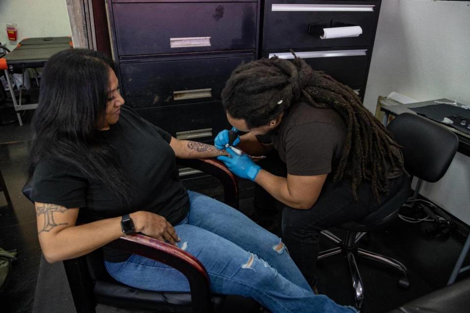 El artista del tatuaje Pharoah trabaja con la clienta Peggy Oquendo en el estudio Da Kandy Shop Tattoo de Arlington.