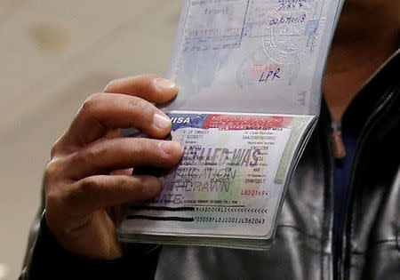 FILE PHOTO: A member of the Al Murisi family, Yemeni nationals who were denied entry into the U.S. last week because of the recent travel ban, shows the cancelled visa in their passport from their failed entry to reporters as they successfully arrive to be reunited with their family at Washington Dulles International Airport in Chantilly, Virginia, U.S. February 6, 2017. REUTERS/Jonathan Ernst/File Photo