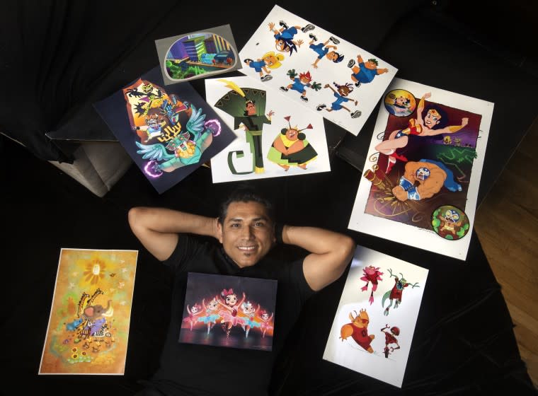 BURBANK, CA -JUNE 02, 2021: Artist Jose Zelaya is photographed next to some of his portfolio pieces at his home in Burbank. Zelaya has worked for Disney since 1997 as a character designer. The Salvadoran immigrant, who has a natural talent for drawing, came to the United States as a teenager and was discovered by a filmmaker who saw him draw at Polytechnic High School in Sun Valley. (Mel Melcon / Los Angeles Times)