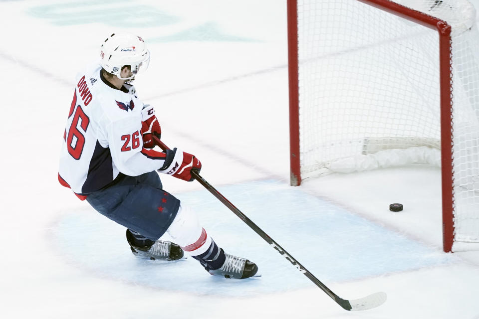 Washington Capitals center Nic Dowd (26) scores on an empty net during the third period of an NHL hockey game against the New Jersey Devils, Saturday, Feb. 27, 2021, in Newark, N.J. The Capitals won 5-2. (AP Photo/Mary Altaffer)