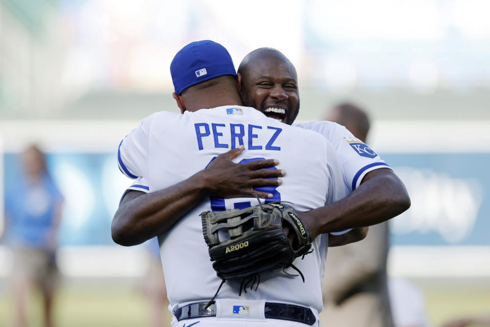 Former Kansas City Royals center fielder Lorenzo Cain, right, hugs Salvador Perez after throwing out the first pitch during a retirement celebration before a baseball game against the Oakland Athletics in Kansas City, Mo., Saturday, May 6, 2023. Cain signed a one-day contract with the team so he could retire as a Royal. (AP Photo/Colin E. Braley)