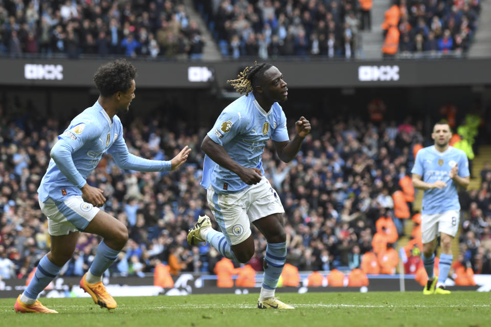Manchester City's Jeremy Doku, centre, celebrates after scoring his side's fourth goal during the English Premier League soccer match between Manchester City and Luton Town at Etihad stadium in Manchester, England, Saturday, April 13, 2024. (AP Photo/Rui Vieira)