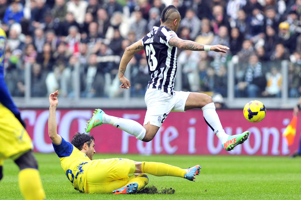 Juventus midfielder Arturo Vidal, of Chile, top, challenges for the ball with Chievo Verona's Adrian Stoian during a Serie A soccer match between Juventus and Chievo Verona, at the Juventus stadium, in Turin, Italy, Sunday, Feb. 16, 2014. (AP Photo/Massimo Pinca)