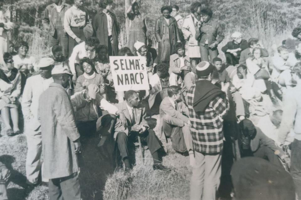 Ernest Doyle (center) holding an NAACP sign at a rest camp site. Doyle and other protesters marched from Selma to Montgomery in 1965. He was also a member of the Courageous Eight, a group that spearheaded the voting rights movement in Selma.