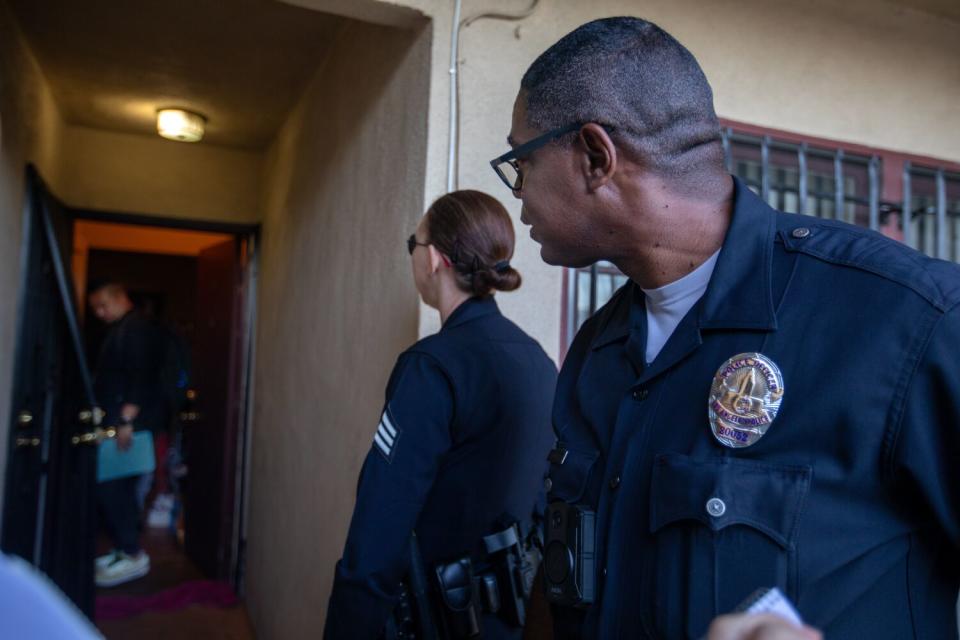 Police look on as a mental health team responds to a man who was reportedly having a mental health crisis.