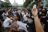 Pro-democracy protesters gather, flashing three-fingered salutes at a main shopping district in Bangkok, Thailand, Sunday, Oct. 25, 2020. Thailand’s government and the country’s pro-democracy movement appeared no closer to resolving their differences Saturday, as the protesters' deadline for Prime Minister Prayuth Chan-ocha to step down came and went with no new action from either side, and no backing down.(AP Photo/Gemunu Amarasinghe )