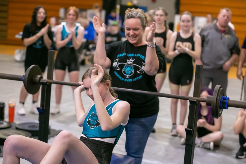 West Port’s Alexis Jeppson celebrates bench pressing 75 pounds as coach Karen Harper cheers her on during the MCIAC girls weightlifting competition at Belleview High School in Ocala, FL on Saturday, January 13, 2024. [Alan Youngblood/Ocala Star-Banner]